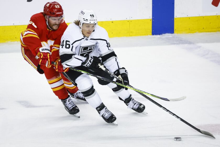 Los Angeles Kings forward Blake Lizotte, right, is checked by Calgary Flames forward Blake Coleman during the first period of an NHL hockey game Tuesday, March 28, 2023, in Calgary, Alberta. (Jeff McIntosh/The Canadian Press via AP)