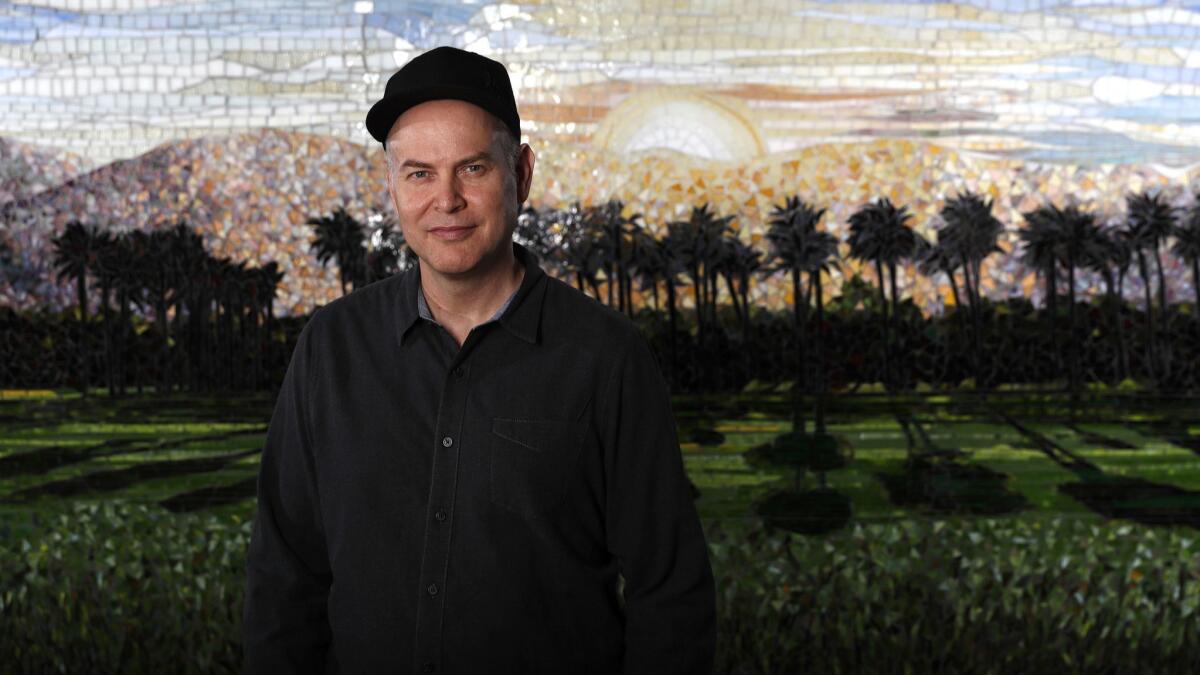 Concert promoter Paul Tollett, president of Goldenvoice Productions, in front of a mosaic of the Coachella landscape at his headquarters in downtown Los Angeles.