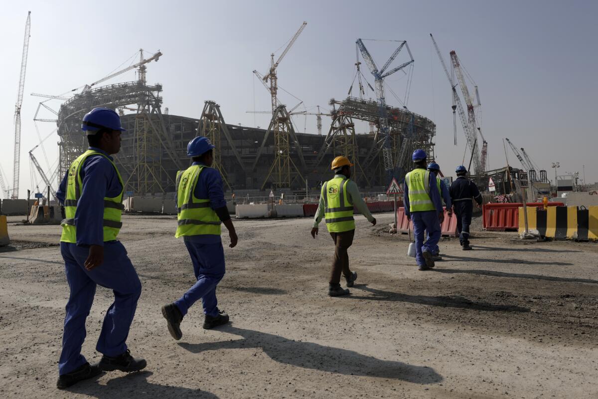 Workers walk to the construction site for Lusail Stadium, one of the 2022 World Cup stadiums