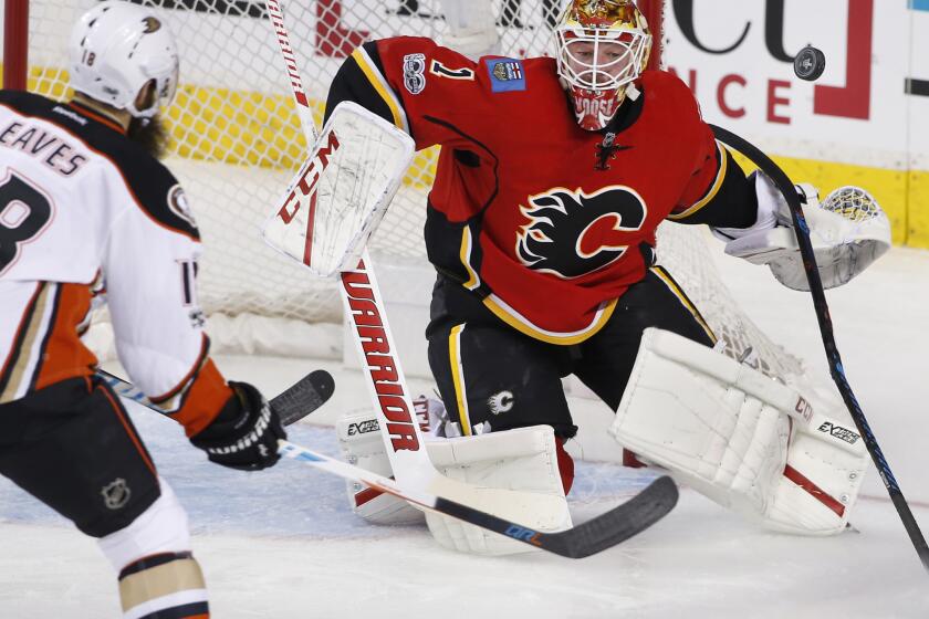 Calgary Flames goalie Brian Elliott, right, makes a save against Ducks forward Patrick Eaves during the first period.