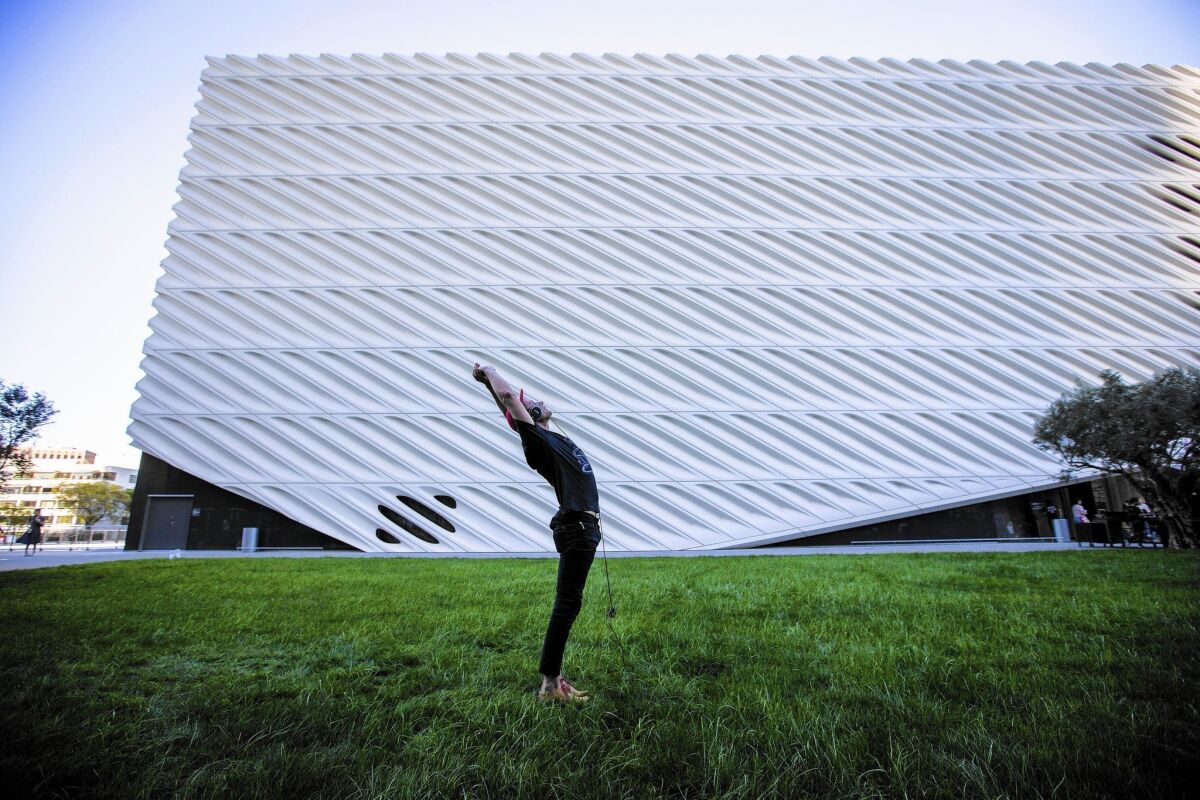 Blakey Olsen, of Laguna Beach, practices yoga in the shade on the cool grass lawn of the Broad Museum in downtown Los Angeles, where Tuesday's high of 89 set a record for the date.