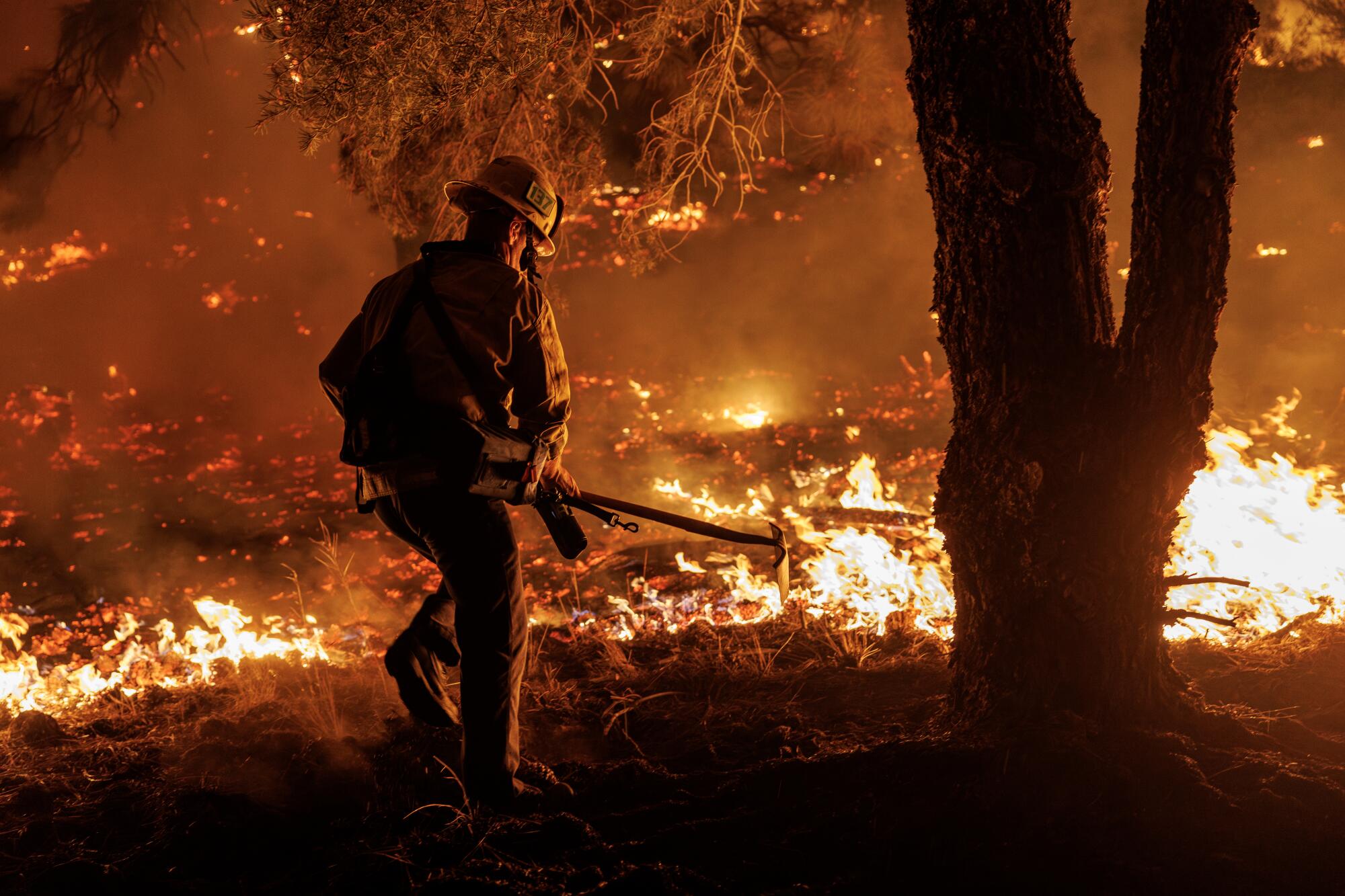 A firefighter battles flames on the ground.