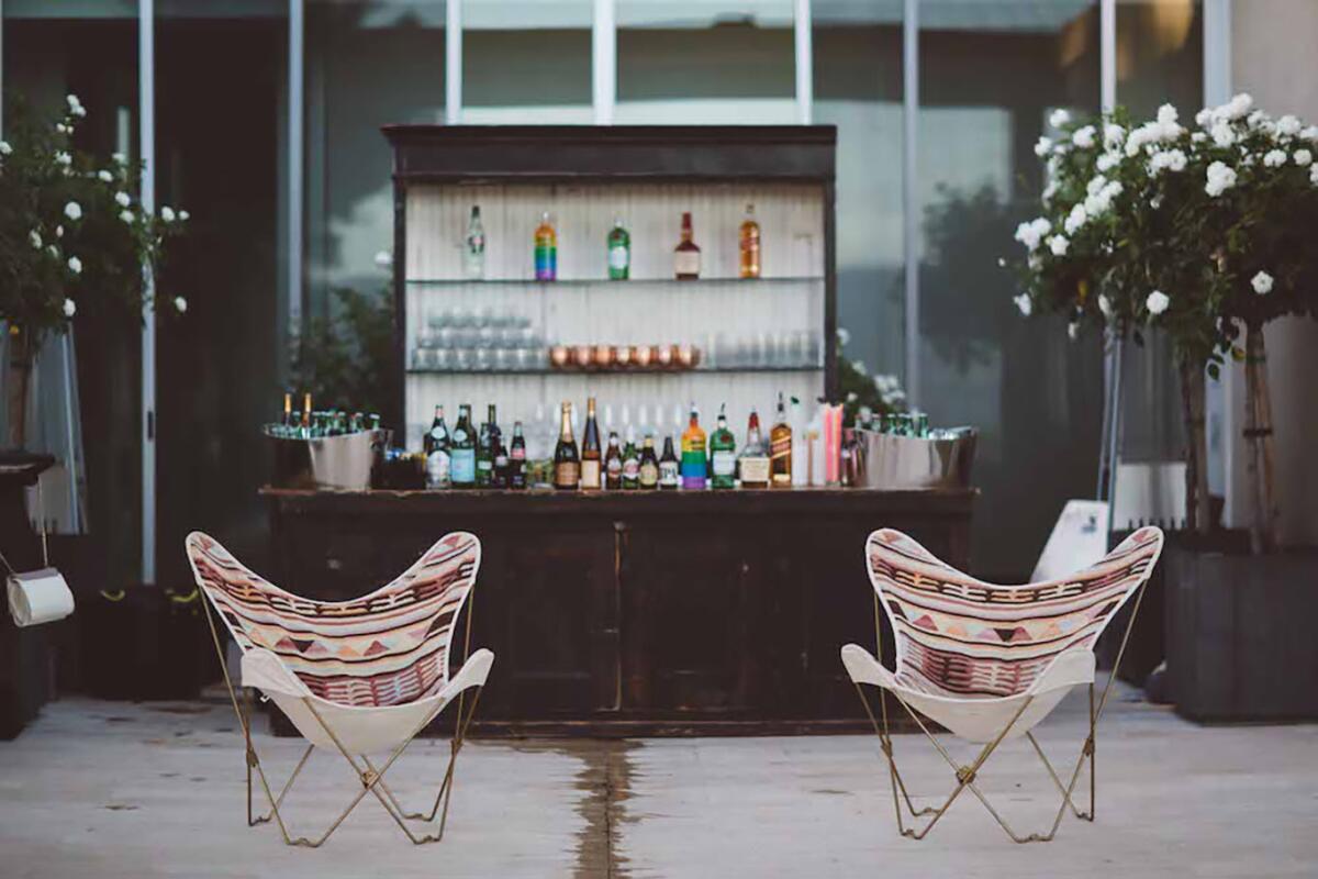 A comfortable seating area next to a backyard wedding bar.