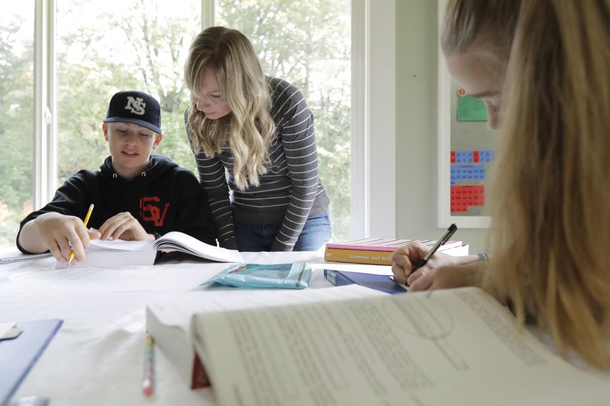 Donya Grant da clases en casa a sus hijos Kemper, de 14 años, y Rowyn, de 11, en Monroe, Washington.