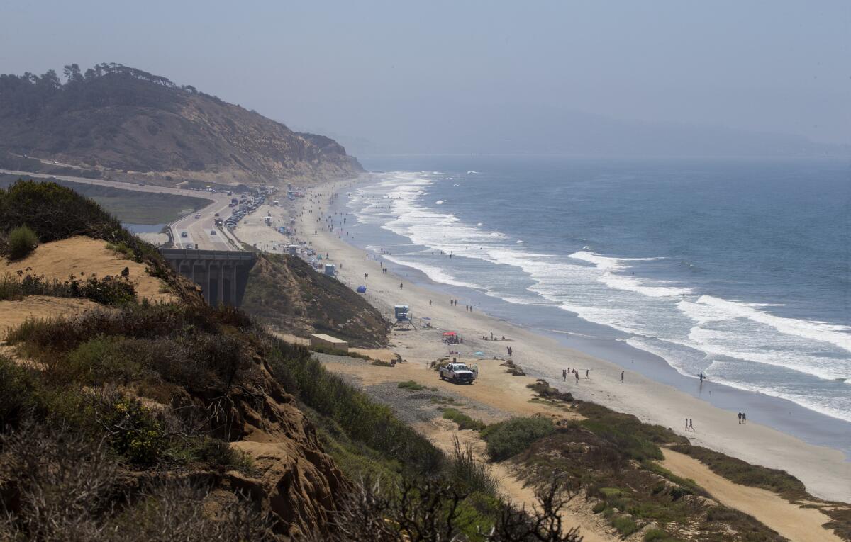 Visitors stroll along Torrey Pines State Beach in San Diego.