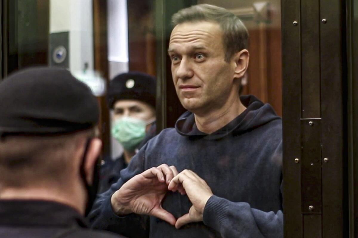 Alexei Navalny holds his hands in the heart symbol in court