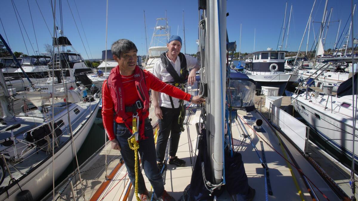 Blind sailor Mitsuhiro "Hiro" Iwamoto, foreground and Doug Smith stand on the deck of Smith's 40-foot sailboat, Dream Weaver in San Diego harbor on Tuesday. The duo leaves Sunday, Feb. 24, on a planned wo-month, 6,000-mile nonstop sailing to Fukushima, Japan.