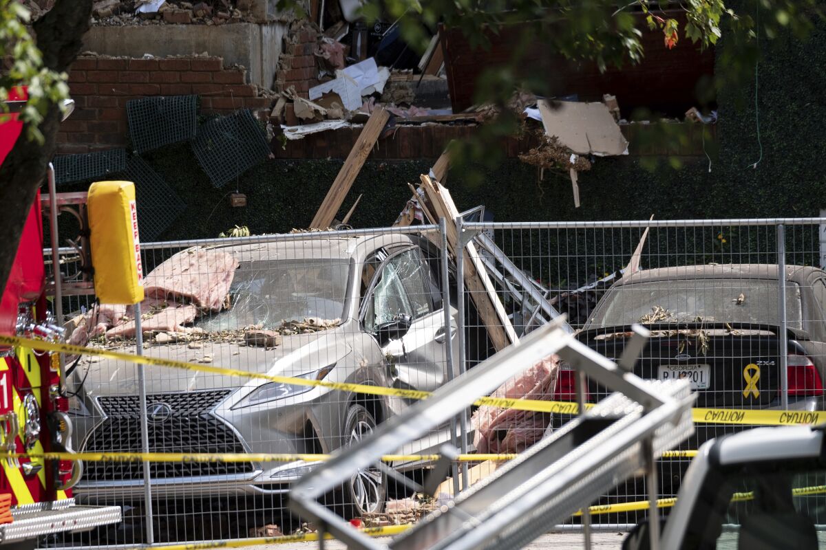 Damaged cars sit in front of an apartment building Monday Sept. 13, 2021 in Dunwoody, Ga., just outside of Atlanta, following an explosion Sunday. (AP Photo/Ben Gray)