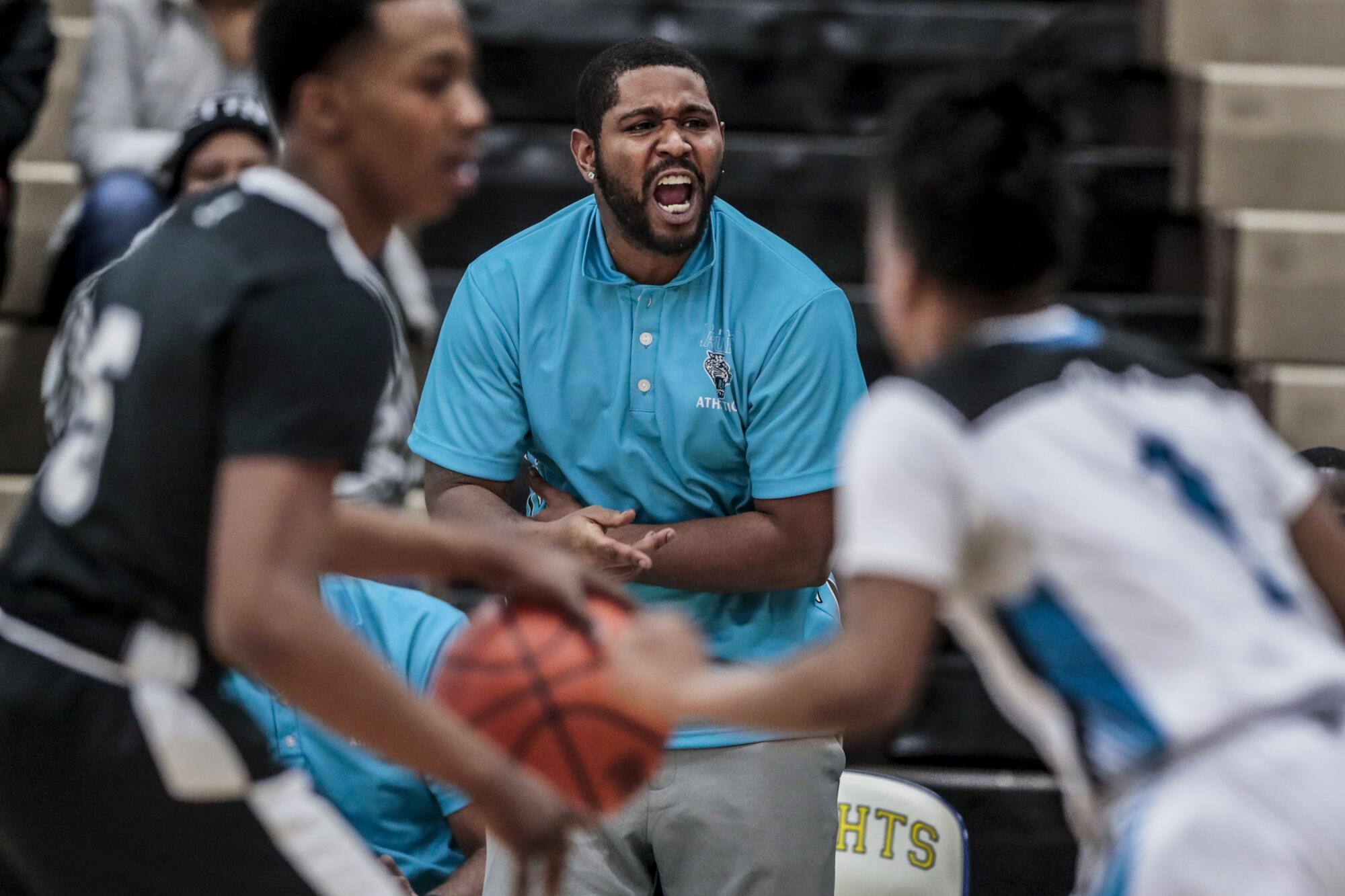 Flint basketball coach Demarkus Jackson shouts instructions to his players during a game against Atherton High.