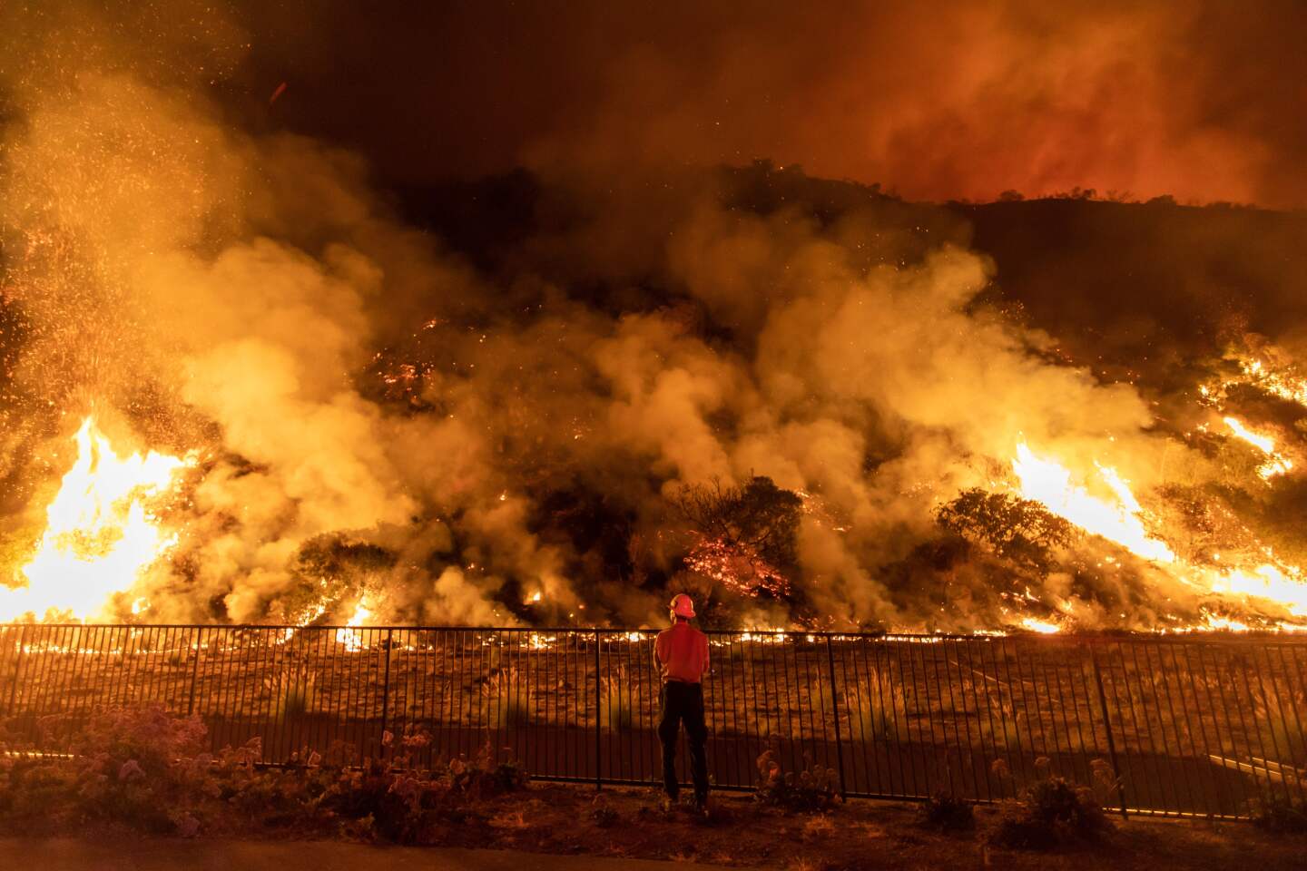 A firefighter battles the smoke and flames from the Ranch Fire in the hills in Azusa.