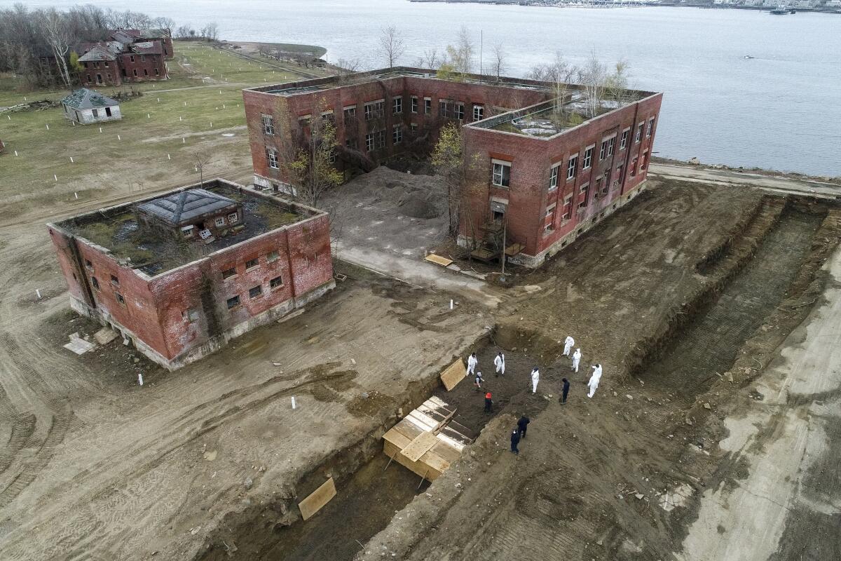 Aerial view of a mass gravesite next to an abandoned building