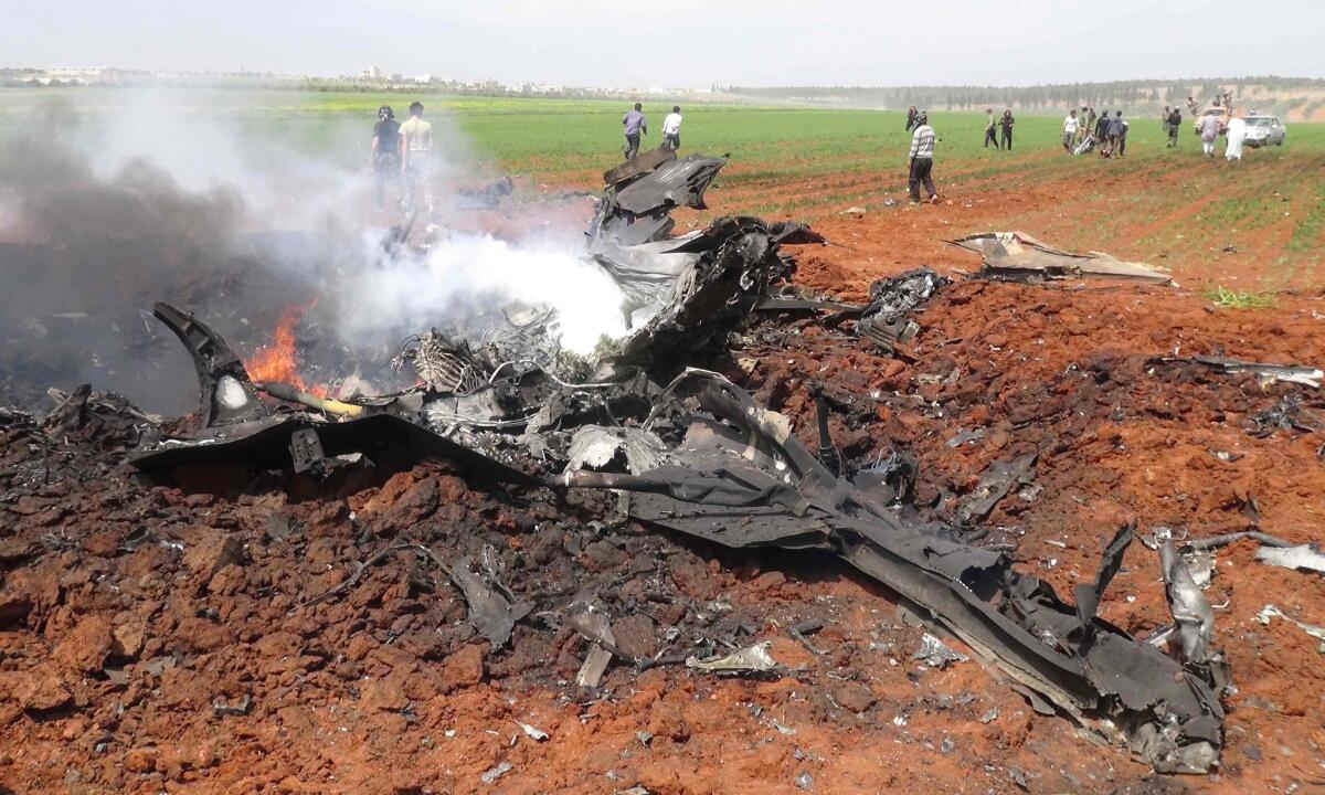The wreckage of a government warplane burns after it was shot down by rebels over the northern Syrian town of Al Eis.