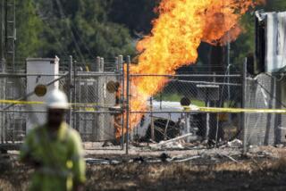 An above-ground valve continues to burn three days after after a vehicle drove through a fence along a parking lot and struck the site, Wednesday, Sept. 18, 2024, in La Porte, Texas. (Jason Fochtman/Houston Chronicle via AP)