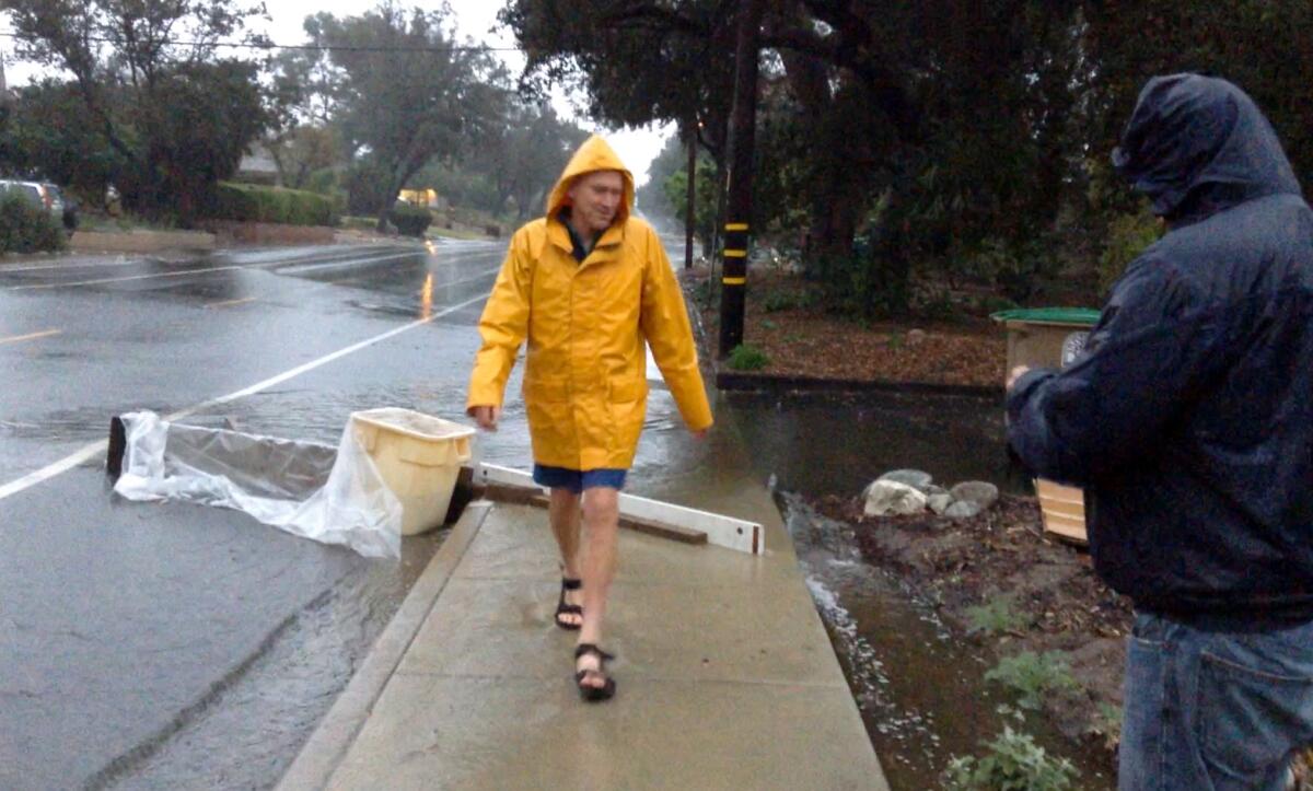 Mark Merritt walks away from an early collection experiment to divert rainwater from the street into his yard.