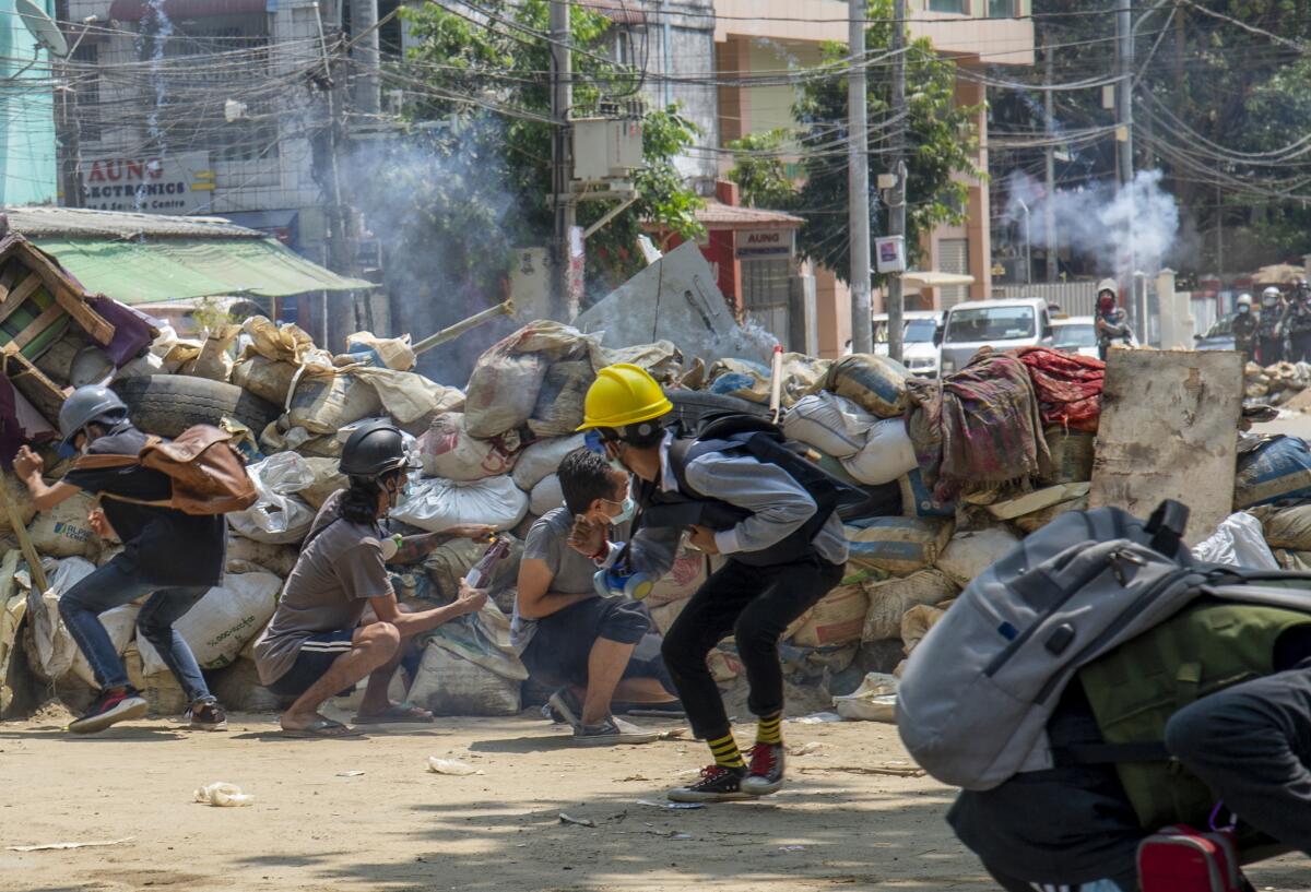 Armed riot policemen charge after firing teargas a rubber bullets as anti-coup protesters abandon their makeshift barricades and run in Yangon, Myanmar Tuesday, March 16, 2021. (AP Photo)