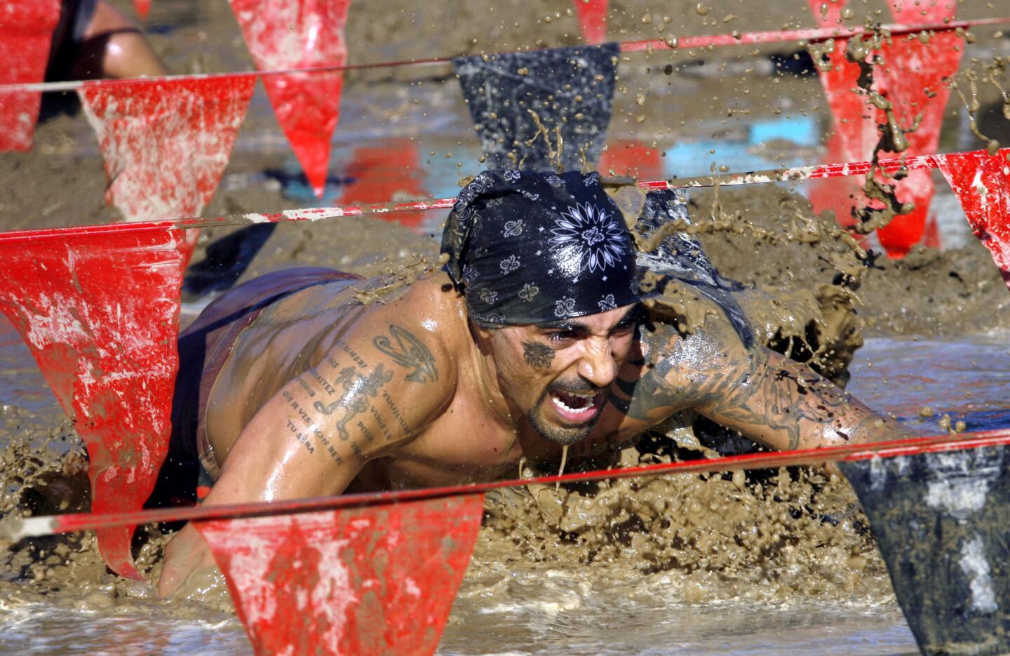 A participant crawls through the mud section of the Gladiator Rock 'n Run.