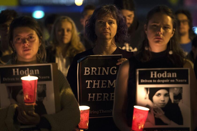 People in Sydney hold a vigil honoring two refugees who set themselves on fire in the remote island of Nauru, where Australia is indefinitely detaining hundreds of asylum seekers.