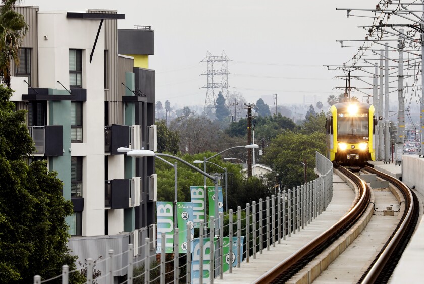A Metro train passes by apartments in Culver City.