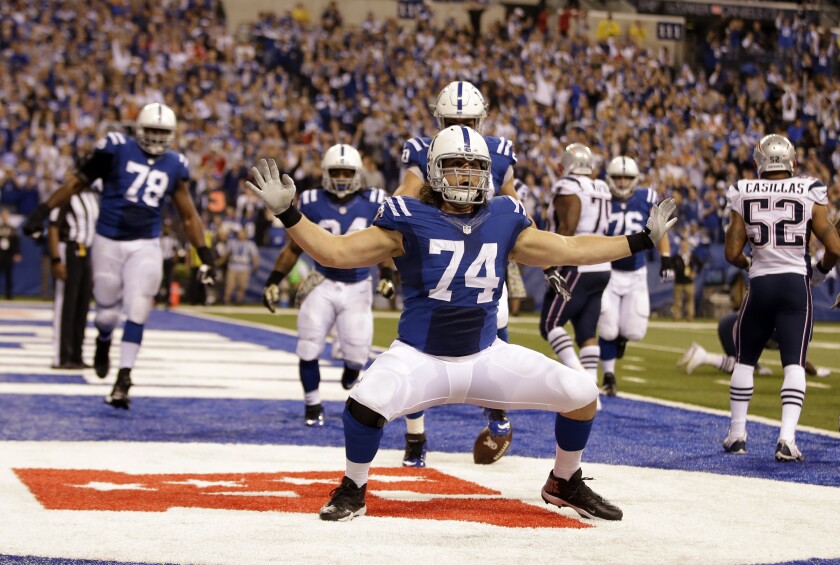 FILE - Indianapolis Colts tackle Anthony Castonzo celebrates after making a catch for a touchdown against the New England Patriots during the second half of an NFL football game in Indianapolis, in this Sunday, Nov. 16, 2014, file photo. Catsonzo, the Colts longtime left tackle, announced his retirement Tuesday, Jan. 12, 2021. The 32-year-old had been an anchor on Indy's offensive line since he was the No. 22 overall draft pick in 2011. (AP Photo/Darron Cummings, File)