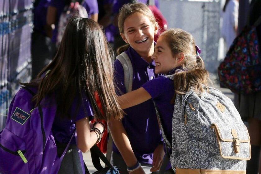 LOS ANGELES CA AUGUST 16, 2016 -- Leila Shiva, right, greets her friends Delia Mizrahi, center, and Alexis Escuadro, left, on first day of classes at the Girls Academic Leadership Academy in Los Angeles Tuesday, August 16, 2016. (Mark Boster / Los Angeles Times).