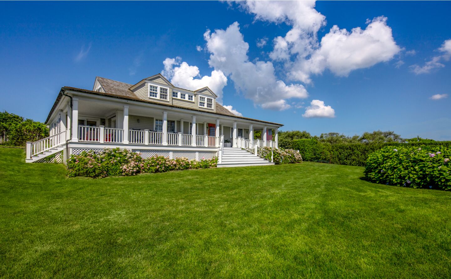 The 1.1-acre estate includes a wood-clad home, detached bungalow, heated pool and catwalk that leads to 150 feet of beach.