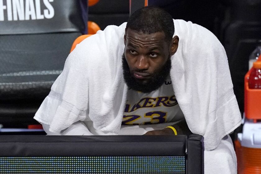 Los Angeles Lakers forward LeBron James watches play against the Denver Nuggets from the bench.