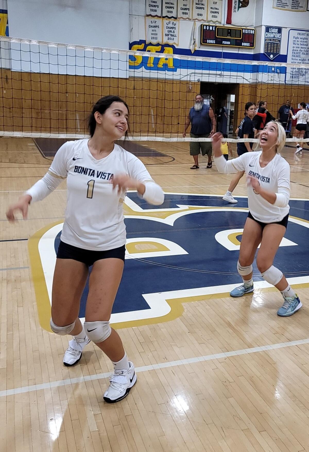 Alina Inzunza (left) and Jaiden Mojica, who is waiting for the ball to come down.