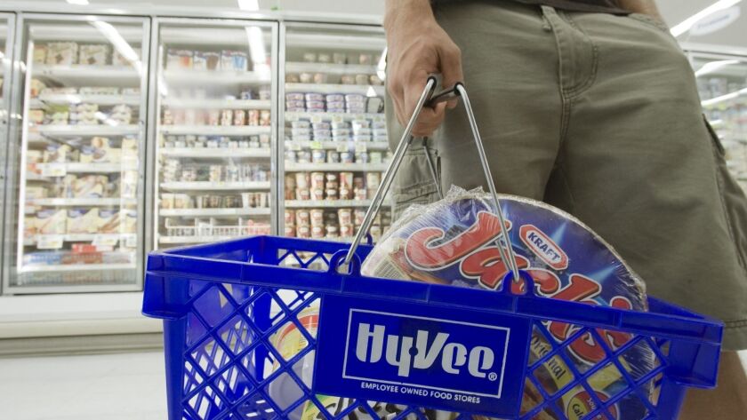 A shopper carries frozen pizza in his supermarket basket. A new clinical trial found that people whose diet consisted of ultra-processed foods consumed 508 more calories per day than people who ate unprocessed foods.