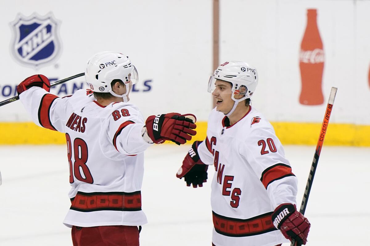 Carolina Hurricanes center Martin Necas (88) is congratulated by center Sebastian Aho (20) after Necas scored the winning goal during an overtime period of an NHL hockey game against the Florida Panthers, Monday, March 1, 2021, in Sunrise, Fla. (AP Photo/Wilfredo Lee)