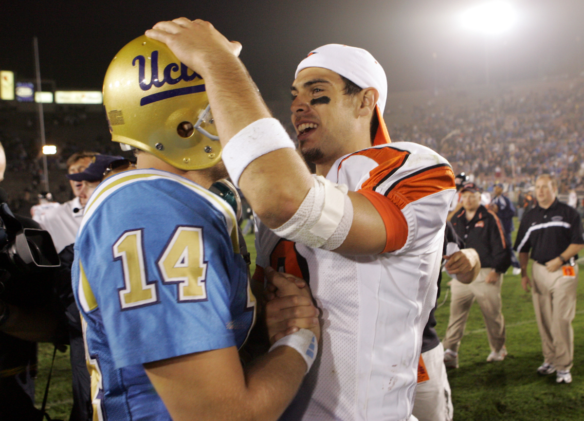 Oregon Eyaleti oyun kurucusu Matt Moore, sağda, eski takım arkadaşı UCLA oyun kurucusu Drew Olson'u selamlıyor.