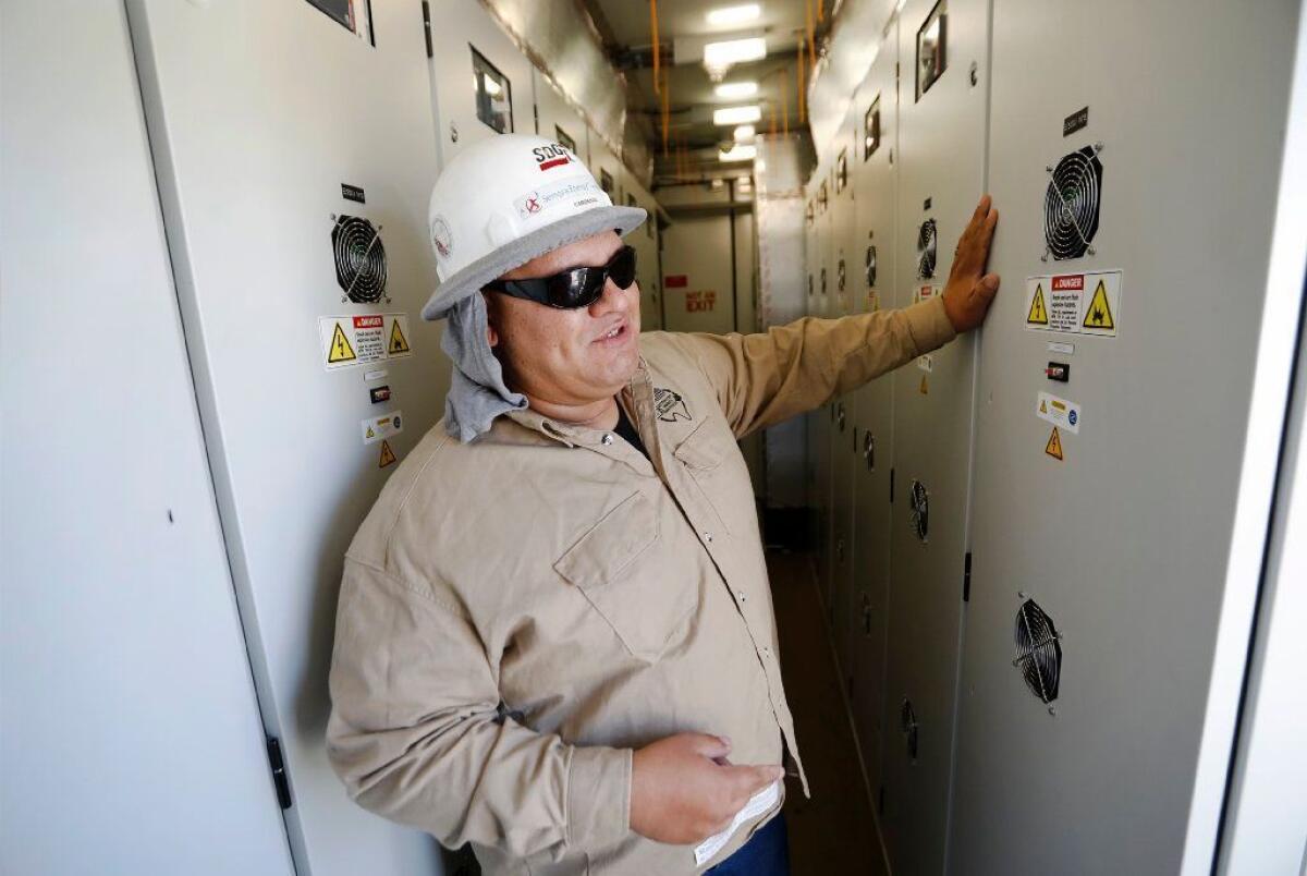 José Cardenas, an engineer with SDG&E, shows the interior of one of several shipping containers packed with lithium-ion batteries at the utility's microgrid in Borrego Springs.