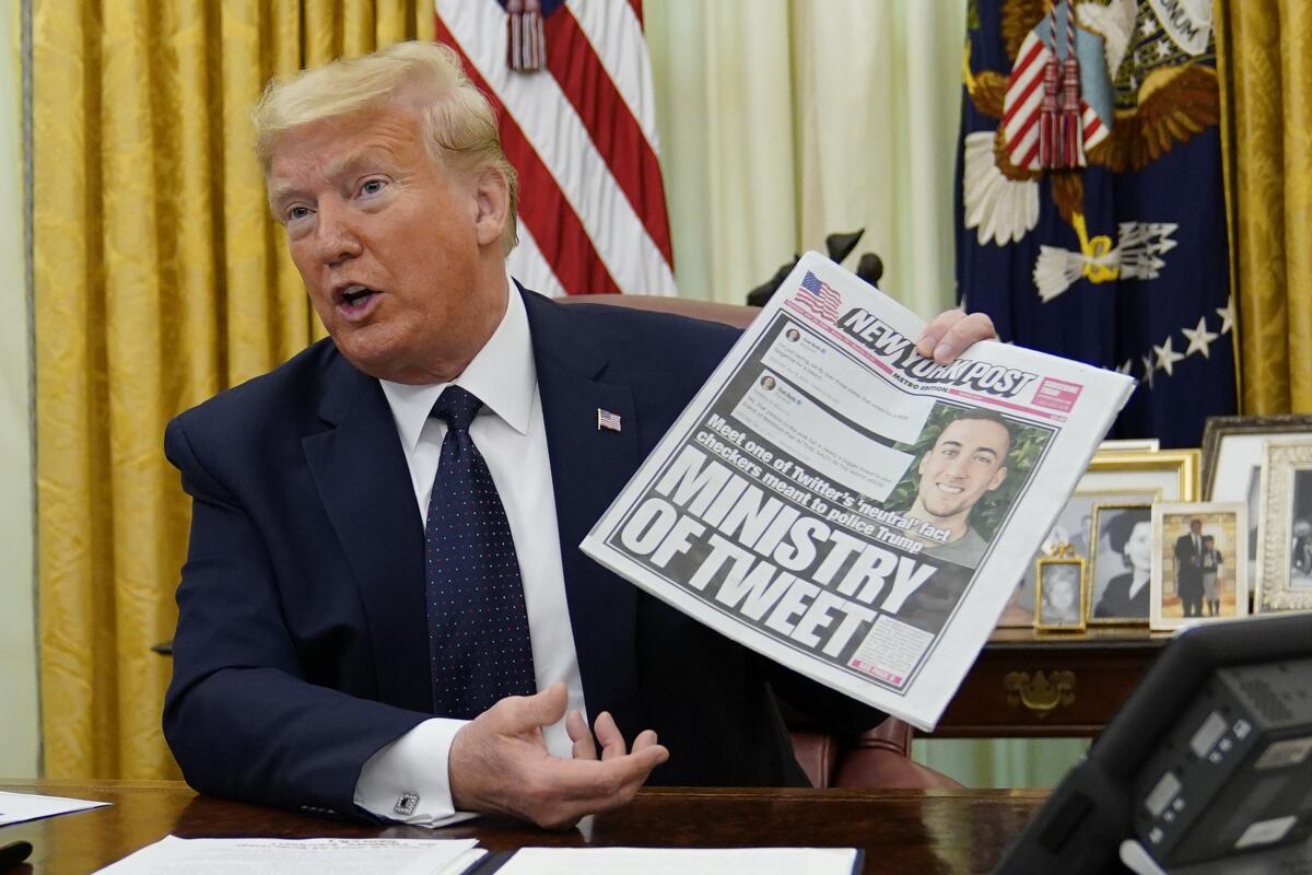 President Trump holds up a copy of the New York Post. 