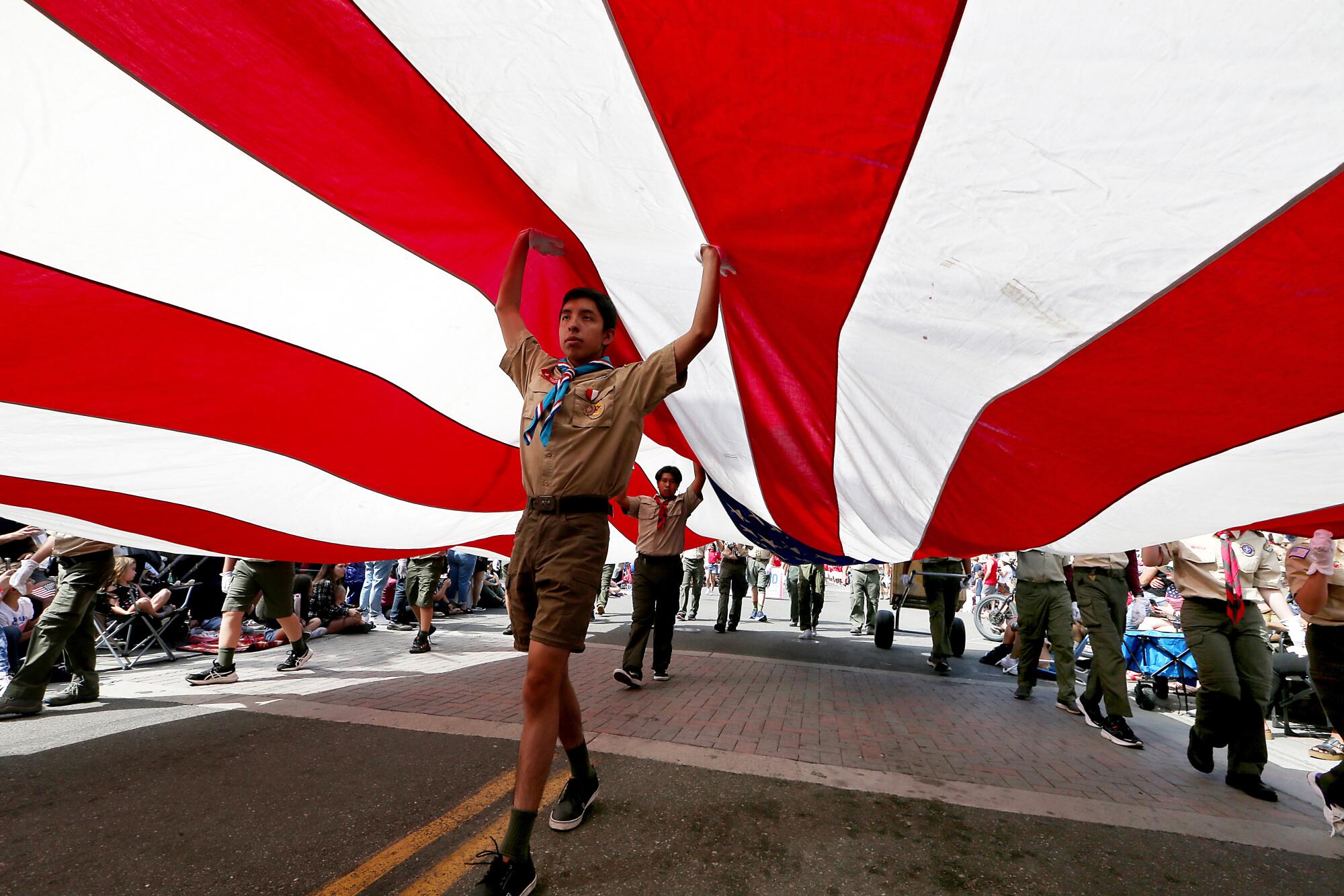 Boys Scouts carry a huge American flag 