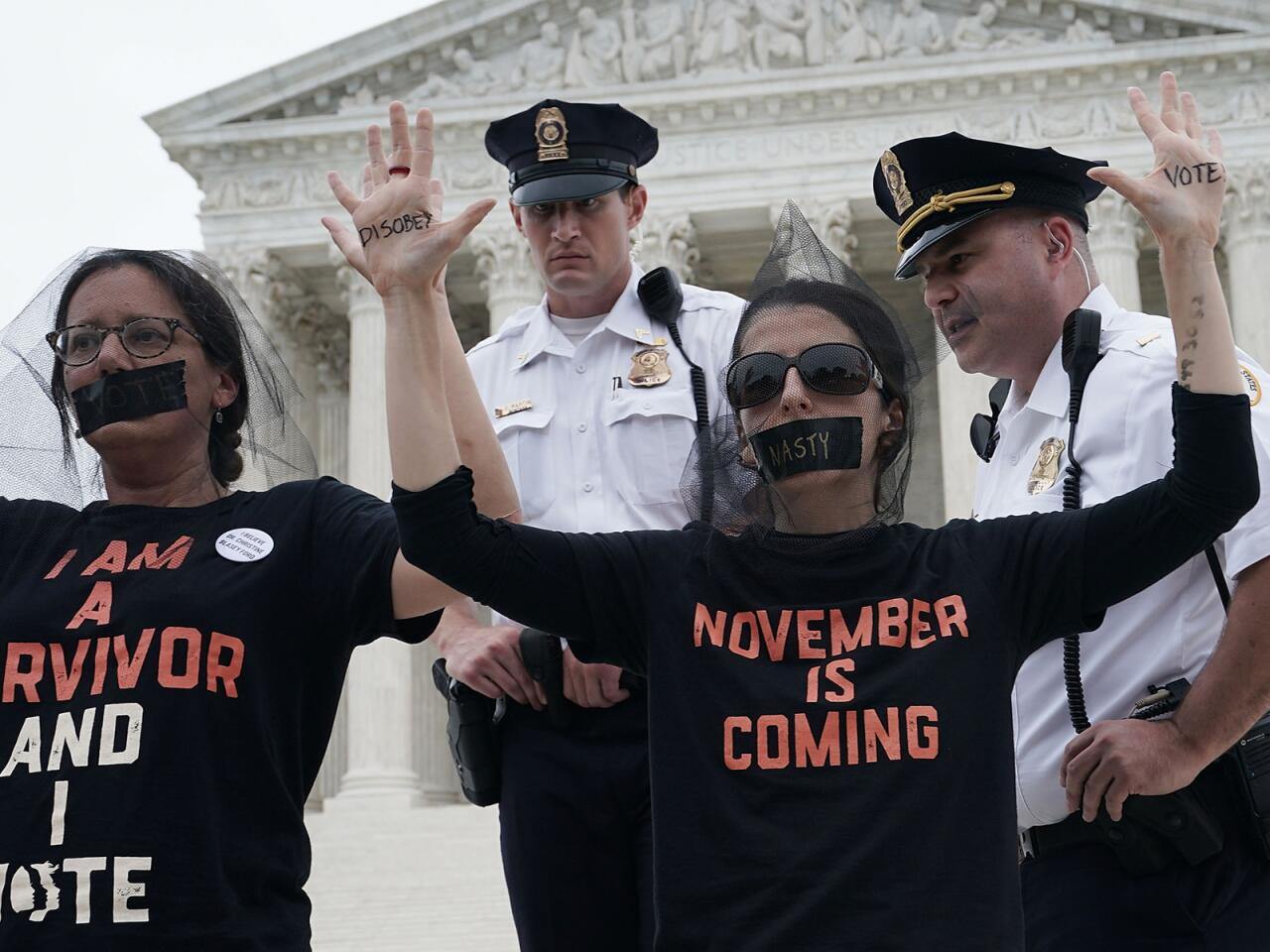 Police warn protesters occupying the front steps of the U.S. Supreme Court on Saturday to rally against the Kavanaugh confirmation.