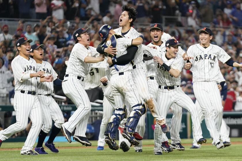 Shohei Ohtani (16) celebrates with his teammates after Japan defeated the U.S. in the WBC 