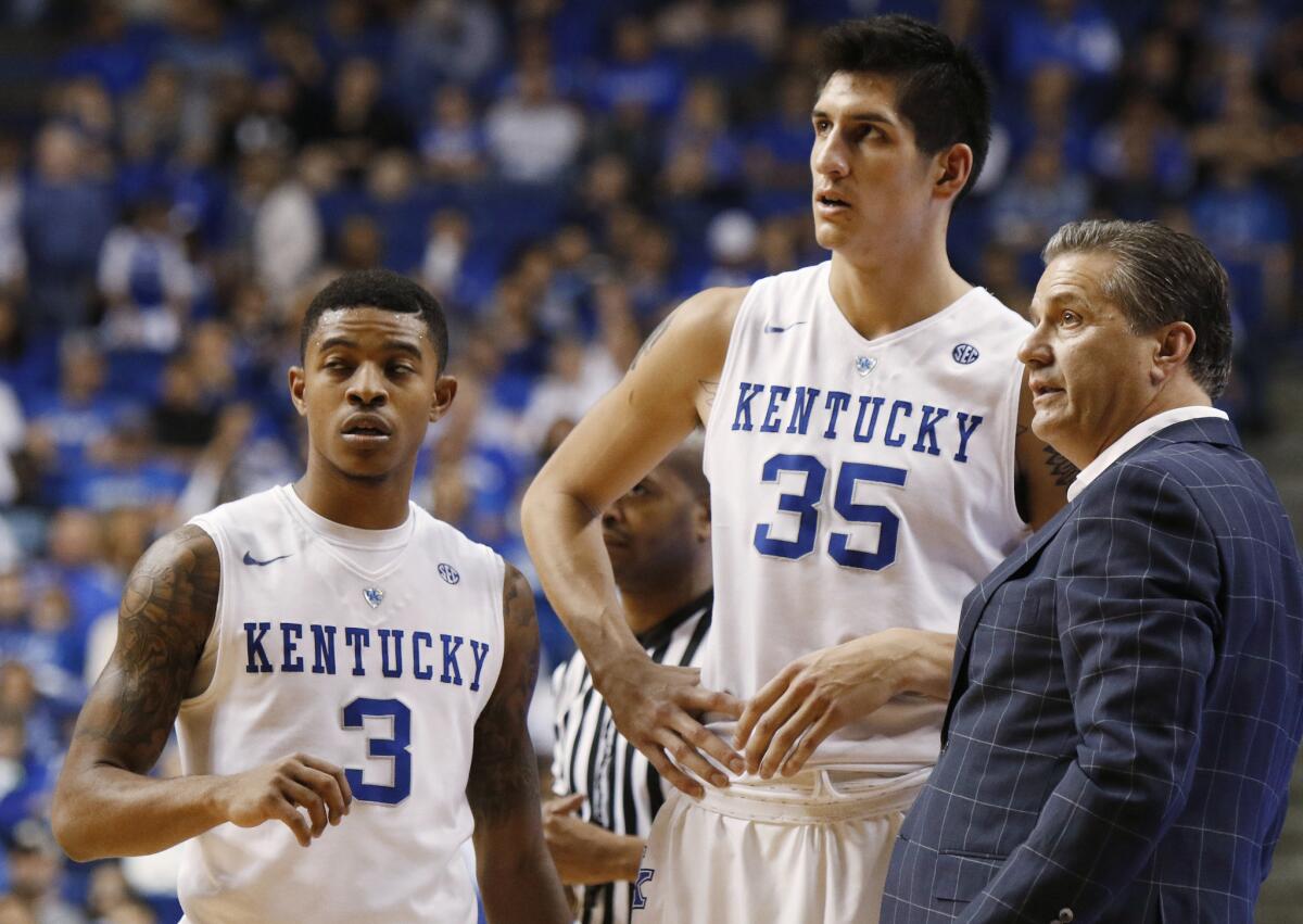 Kentucky's Tyler Ulis (3) and Derek Willis (35) receive instruction from Coach John Calipari during the second half of an exhibition game.