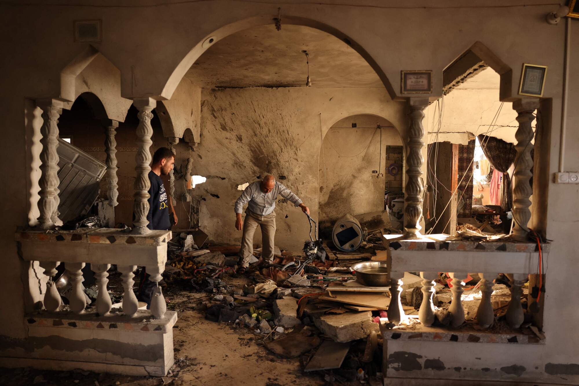 Men inspect a damaged home. 