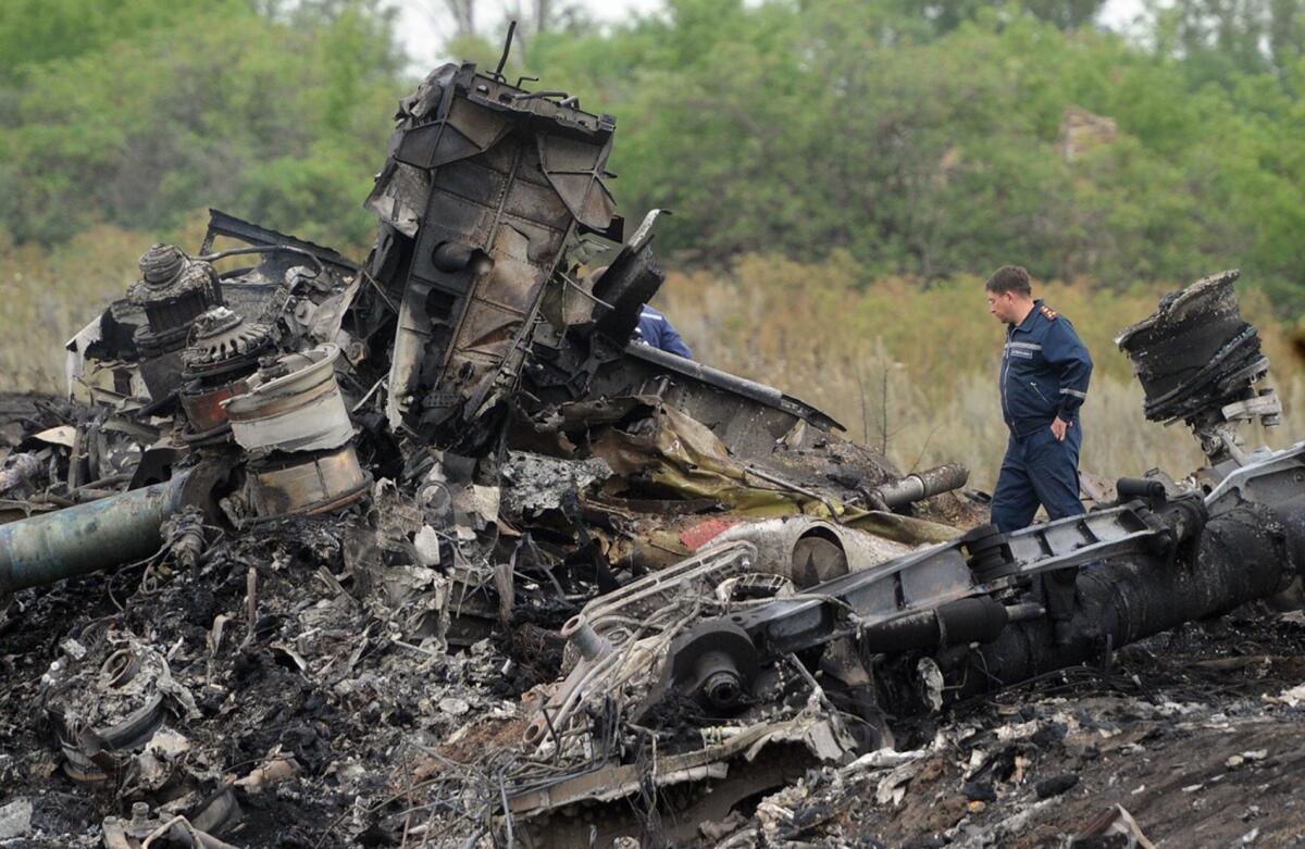 Rescuers stand on July 18 at the site of the crash of a Malaysia Airlines jet near the town of Shaktarsk in eastern Ukraine.