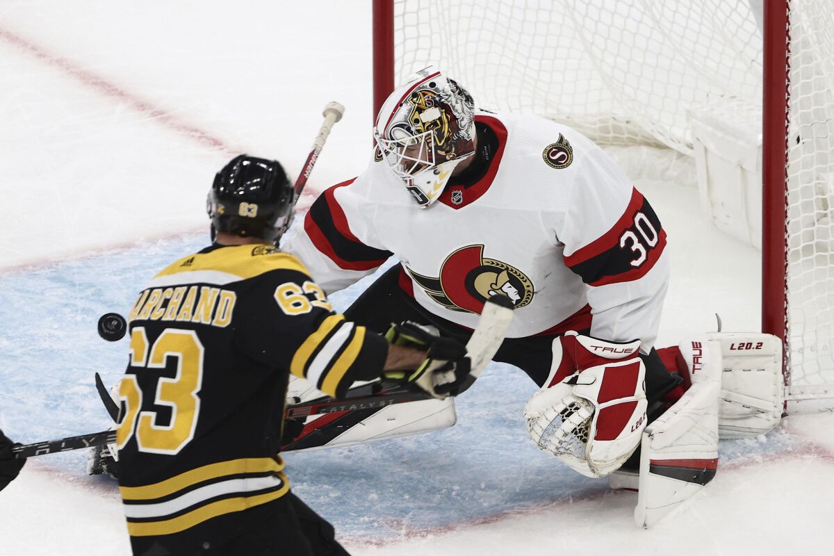 Ottawa Senators goaltender Matt Murray makes a save as Boston Bruins' Brad Marchand looks for the rebound during the first period of an NHL hockey game Tuesday, Nov. 9, 2021, in Boston. (AP Photo/Winslow Townson)