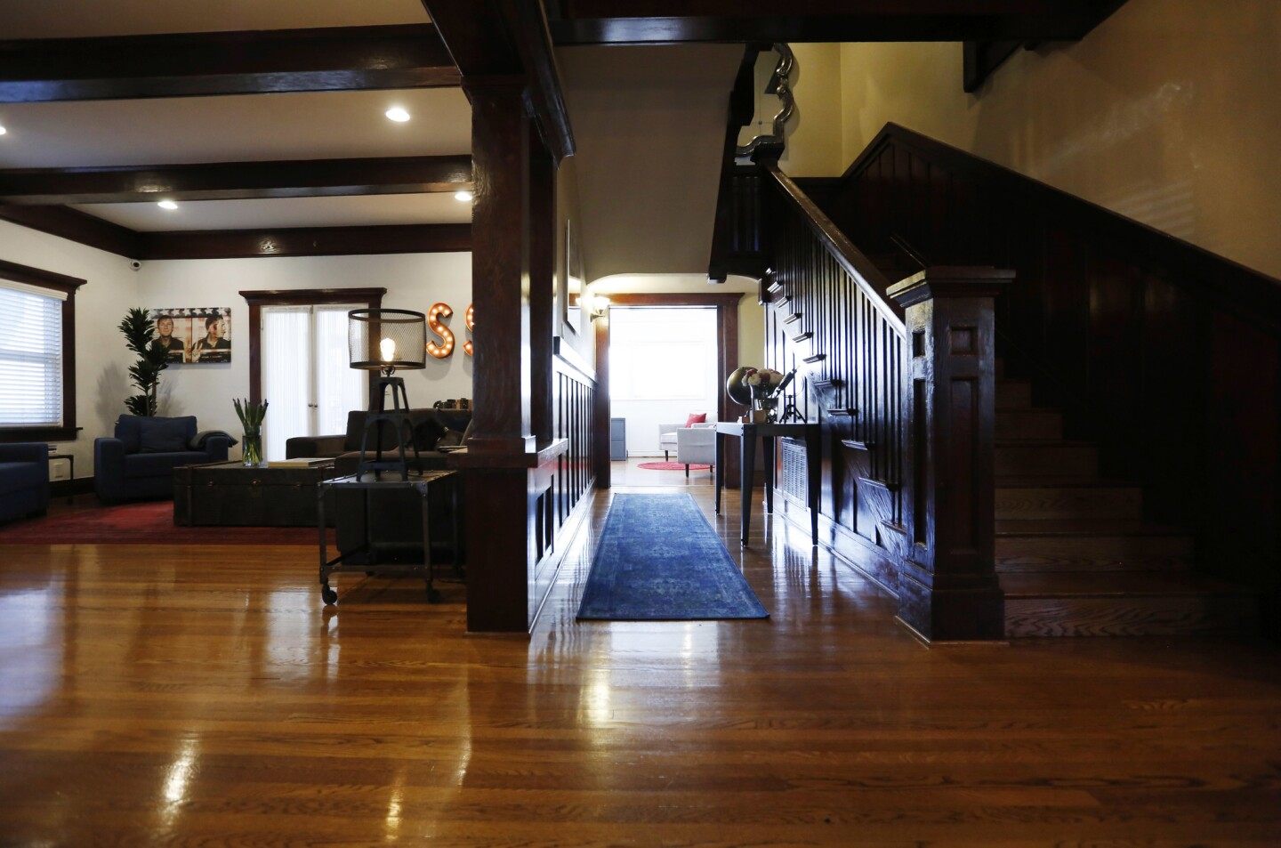 The entrance to Cassandra Corum and Shannon Reese's 1910 Craftsman home in Koreatown features a dark walnut grand staircase.