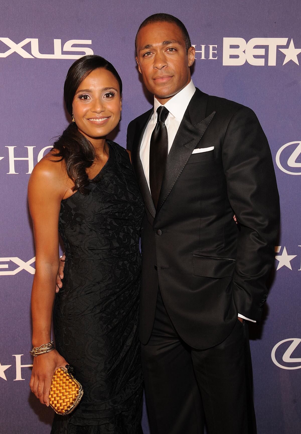 A stylish woman and man stand close together and pose in semiformal attire at an event