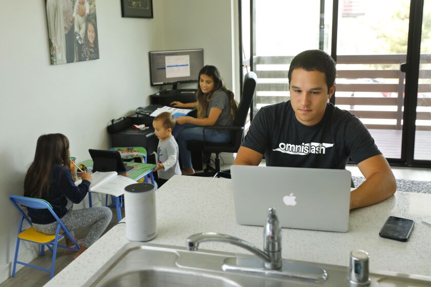 Lucas Fernandez is working a hybrid model where he works at home part of the time and at the office other times. His Deicy is also working from home and the two do so while watching their children, Lucas Jr., 2, and Vienna, 7, at their La Mesa apartment.