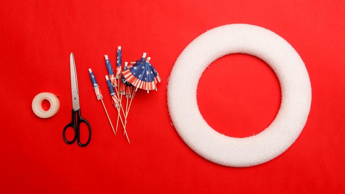 Tape, scissors, flags and a Styrofoam ring are the items needed for the Fourth of July umbrella wreath.