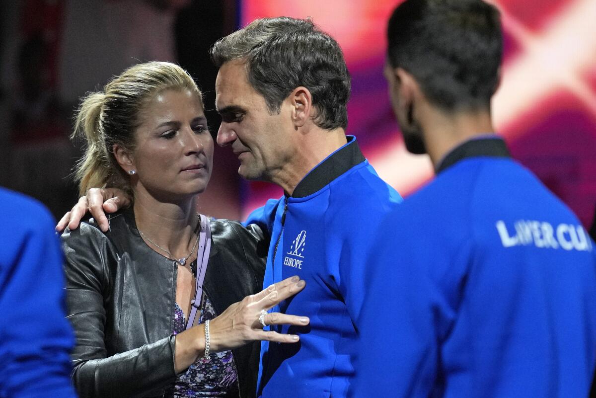 An emotional Roger Federer is embraced by his wife, Mirka, after playing in the final match of his career.