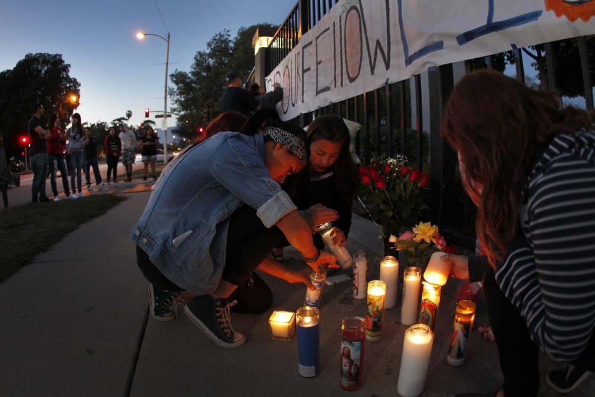 El Monte High School students light candles in front of the school at a memorial to Adrian Castro, a senior at the school killed Thursday in a Northern California bus crash.