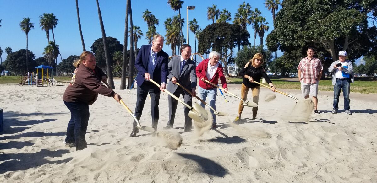 Sarah Mattinson (Area 6 Mission Beach Town Council rep), Mayor Kevin Faulconer, Andy Field (Parks and Rec Department assistant director), William Gardner (husband to the late Maruta Gardner) and Cordelia Mendoza (president of Mission Beach Women's Club) each shovel sand in the Bonita Cove Playground Groundbreaking Ceremony.