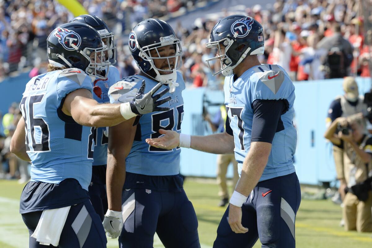 Tennessee Titans quarterback Ryan Tannehill celebrates with teammates after scoring a touchdown.