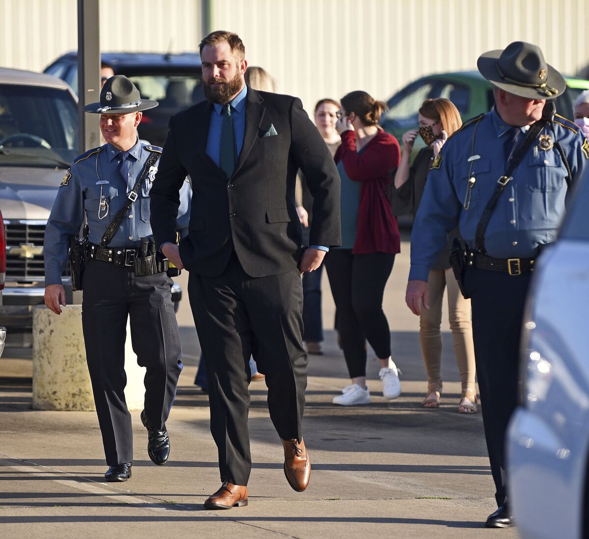 Arkansas State Troopers escort former Lonoke County sheriff's deputy Michael Davis into the Cabot Readiness Center on Thursday, March 17, 2022, for the third day of Davis's manslaughter trial in Cabot, Ark. Jurors began deliberating Thursday in the manslaughter trial of the former Arkansas deputy, who fatally shot Hunter Brittain, an unarmed 17-year-old, during a traffic stop. (Staci Vandagriff/The Arkansas Democrat-Gazette via AP)