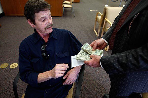 Steve Schulman, left, who was badly hurt when a big rig ran over him in Encino, receives a portion of his settlement from his attorney, Gary Casselman. Schulman was found dead Aug. 17, 2010. See full story See earlier Times profile