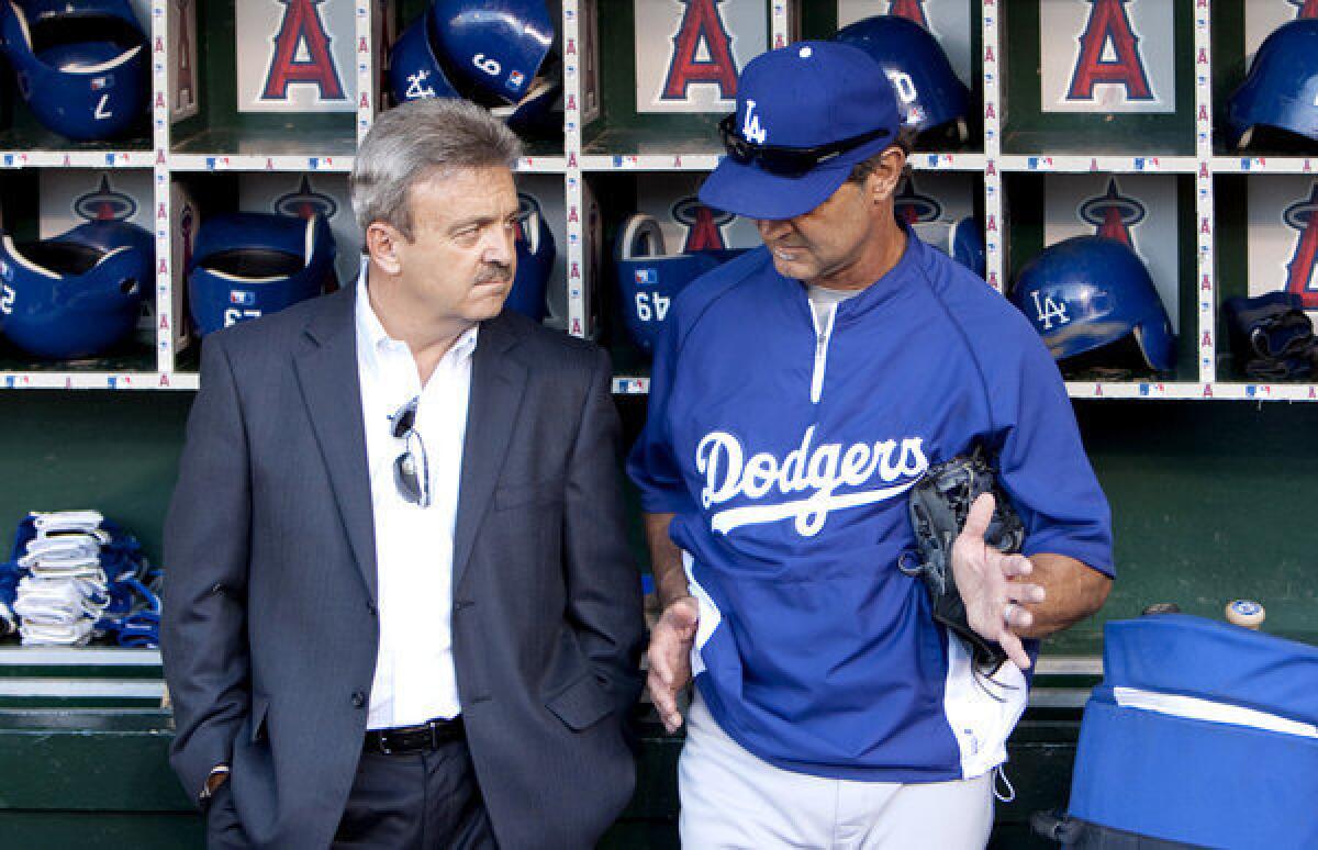 Dodgers General Manager Ned Colletti talks with Manager Don Mattingly before a game against the Angels in 2011.